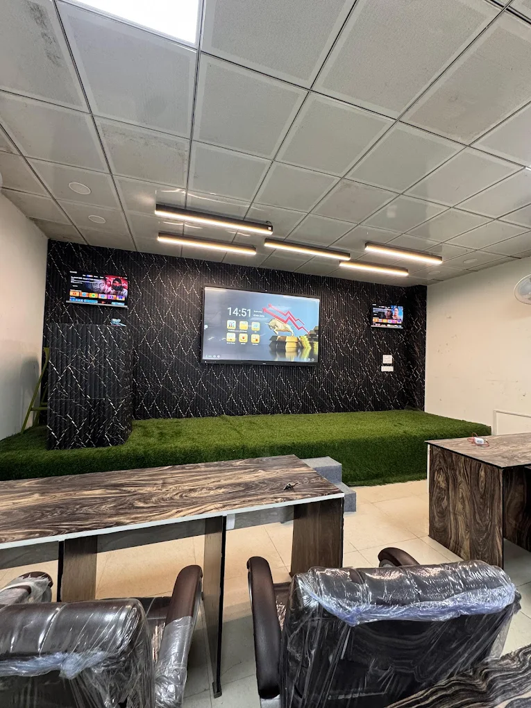 Modern trading classroom with multiple screens and green seating